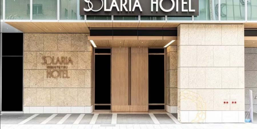The hotel building's facade, featuring large windows and a welcoming entrance.